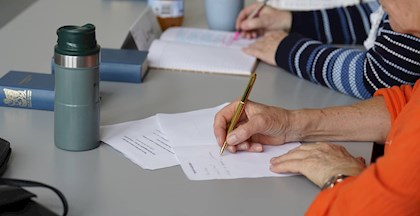 Kvinde skriver med pen og papir, skrivekursus i FOF Aarhus