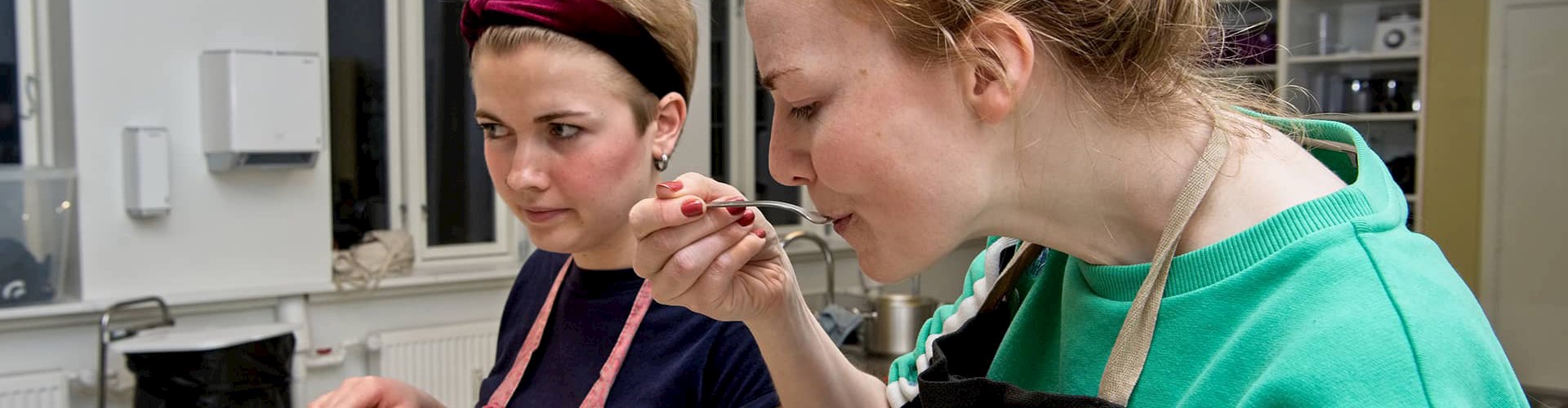 Kvinde der smager på mad på madlavningskursus ved FOF Aarhus