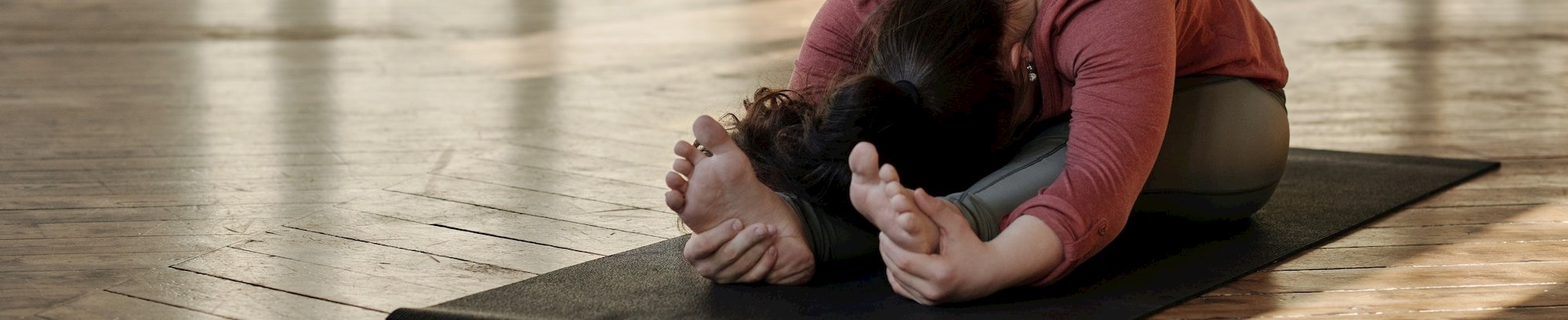 Kvinde strækker ud i yogastilling FOF Køge Bugt