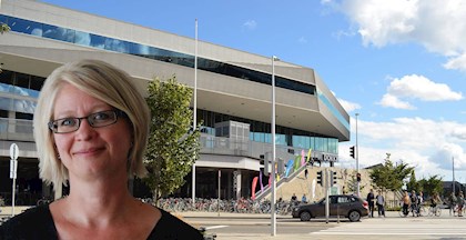 Bibliotekschef Marie Østergaard fra Dokk1, foran bygningen. Bag facaden med FOF Aarhus.