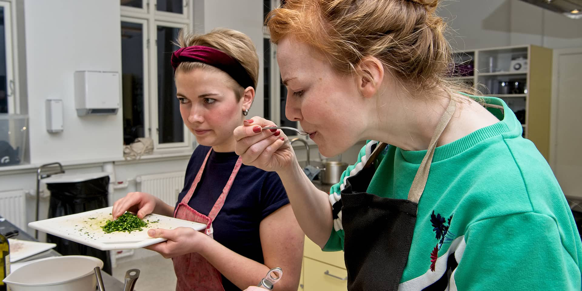 Kvinde der smager på mad på madlavningskursus ved FOF Aarhus