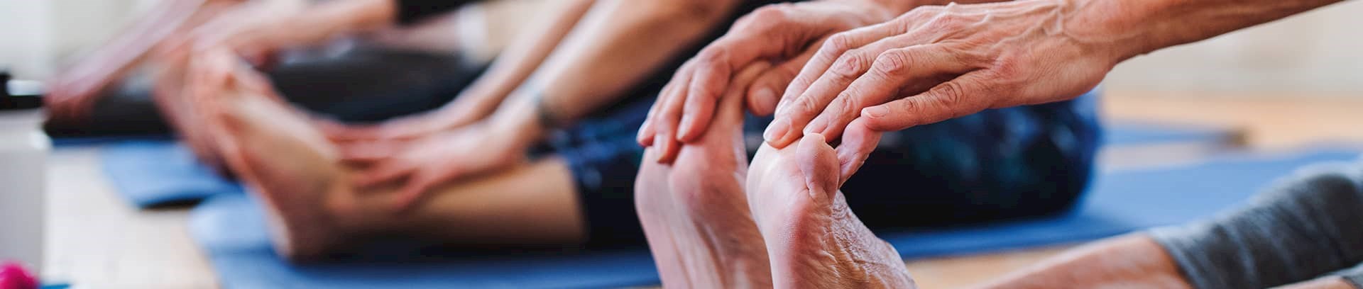 Kvinde der holder på sine fødder på en yogamåtte ved FOF Aarhus