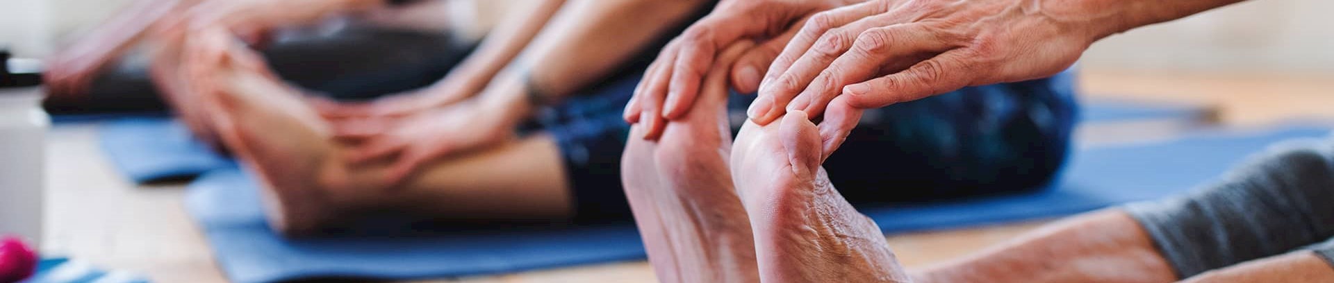 Kvinde der holder på sine fødder på en yogamåtte ved FOF Aarhus