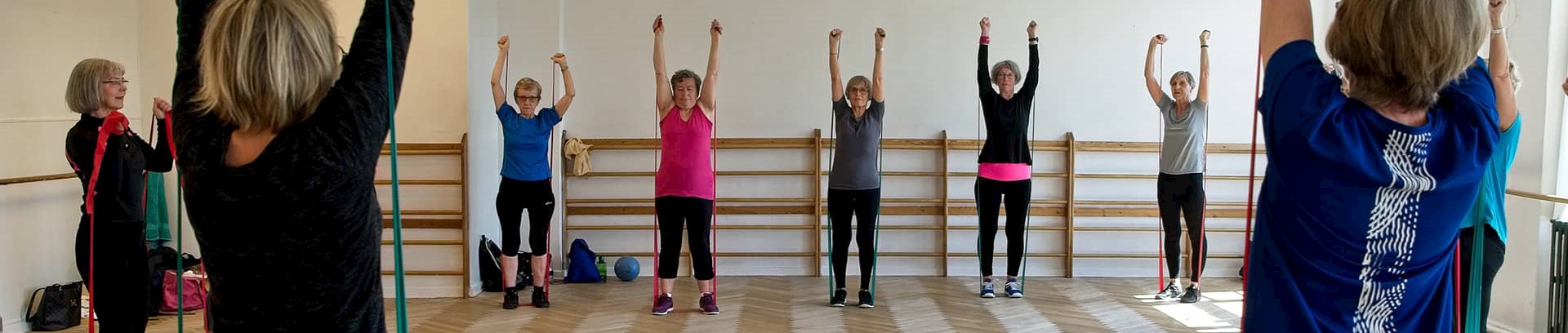 Kvinder der laver øvelser med elastik til træning ved FOF Aarhus