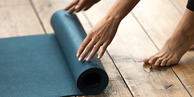Billede af kvinde der ruller yogamåtte sammen