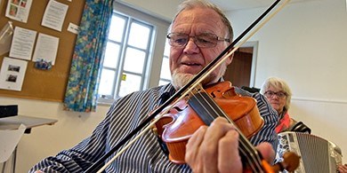 Billede af mand der spiller violin på kusus ved FOF Aarhus
