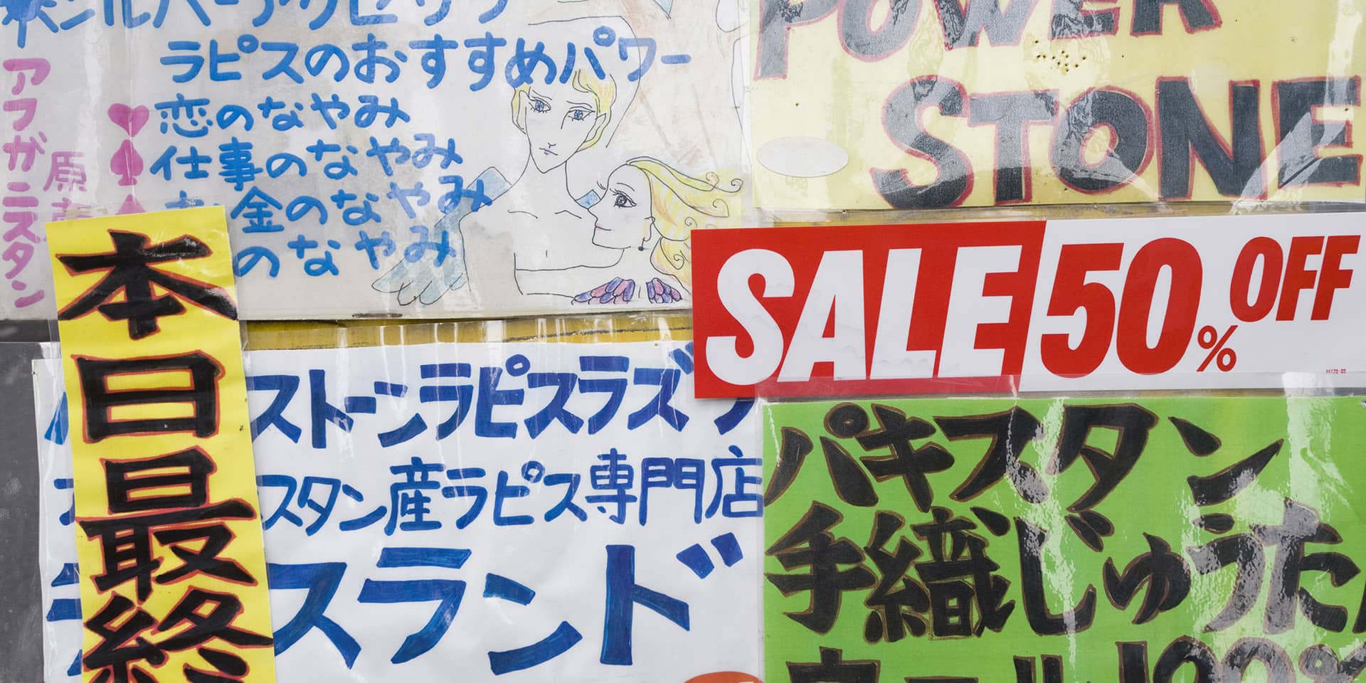 Billede af butiksvindue med tilsalg skilte skrevet med japanske skrifttegn