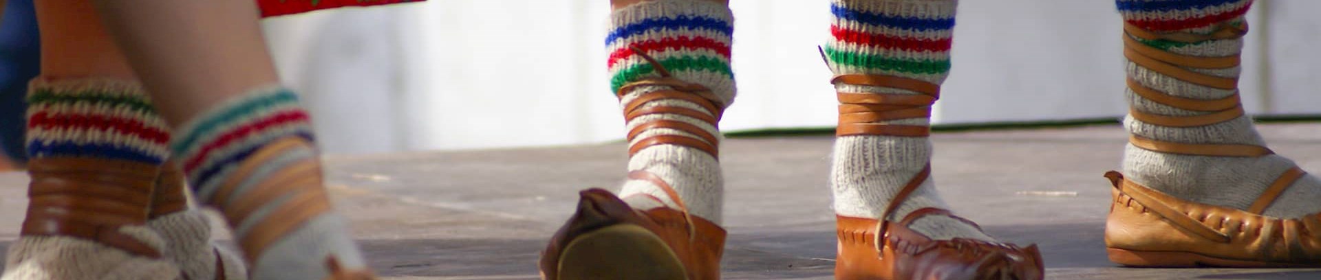 Billede af fødderne af polske folkedansere med uldne striksokker i lædersko