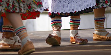 Billede af fødderne af polska folkedansere med uldne striksokker i lædersko