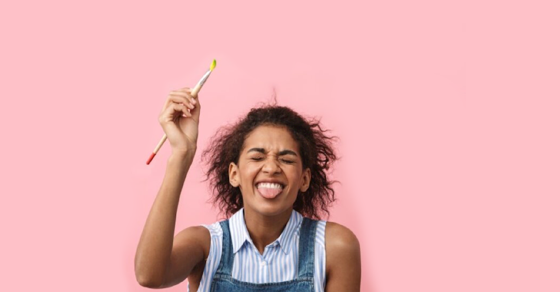 Kvinde med pensel på lyserød baggrund