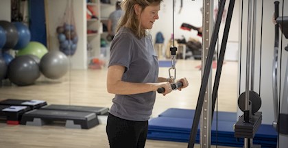 billede af kvinde der træner i træningsmaskine