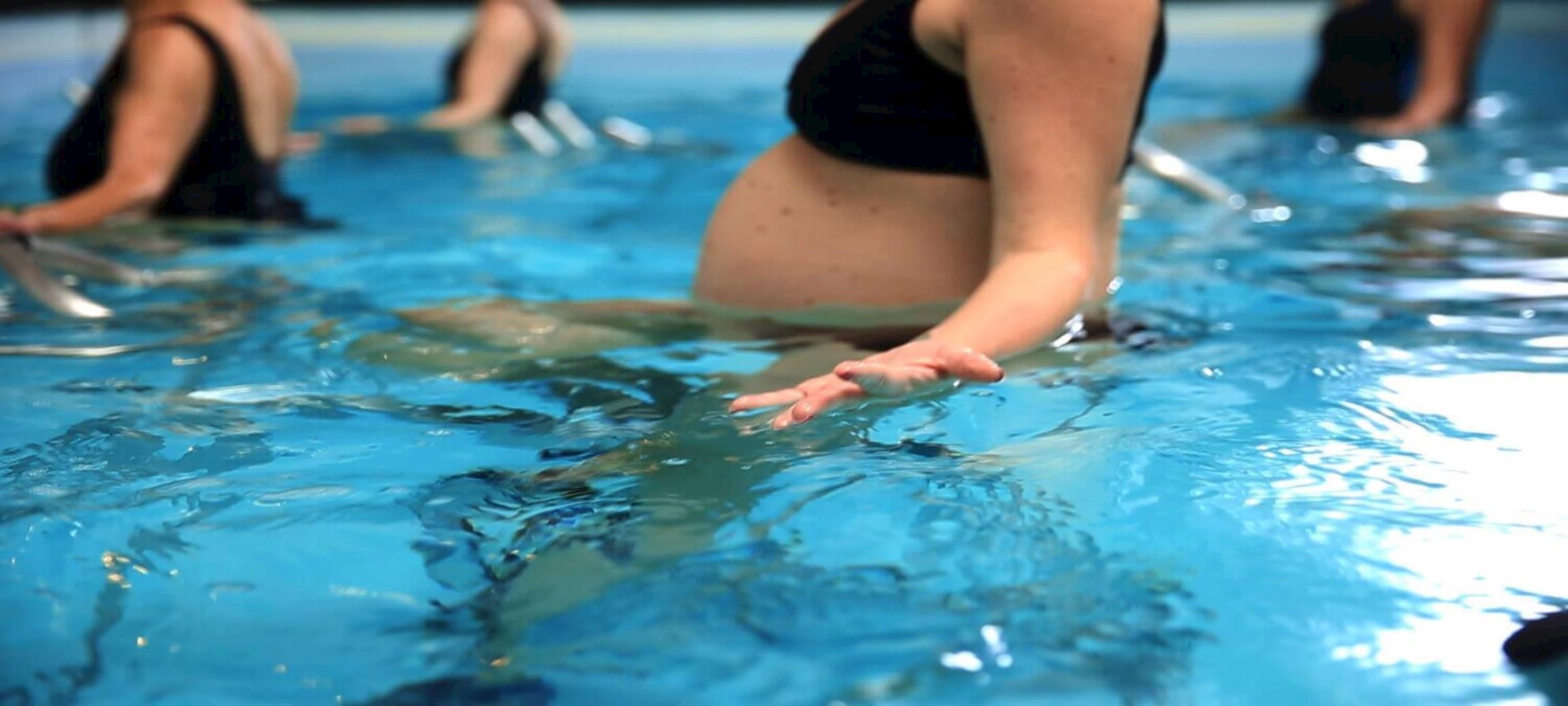 Closeup af gravide kvinder som dyrker vandgymnastik