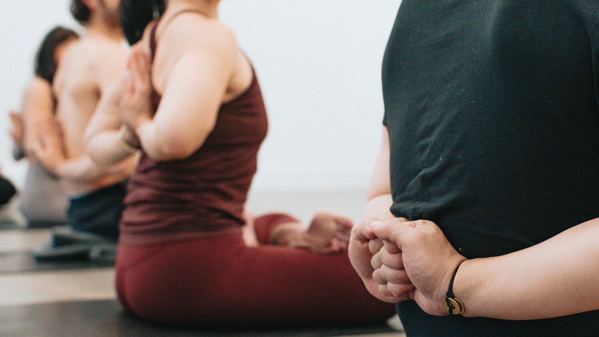 Gruppe af kursister laver hensyntagende yoga på gulv