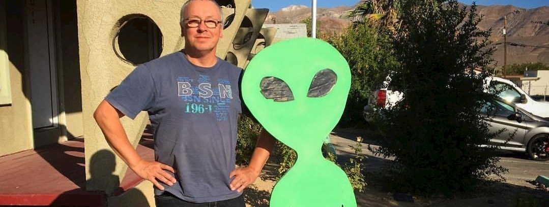 Michael Linden Vørnle foto i solskin ved siden af en grøn alien