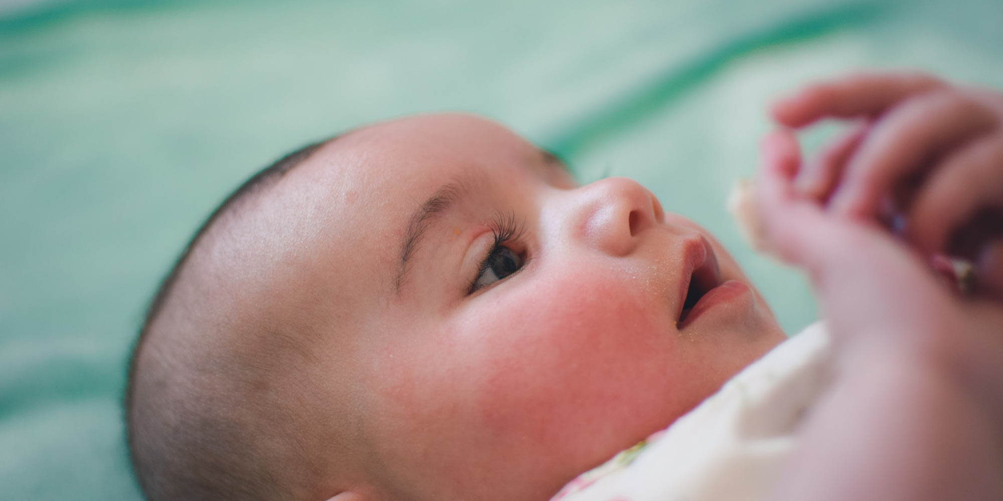 close-up af baby spædbarn som ligger og kigger opmærksomt op