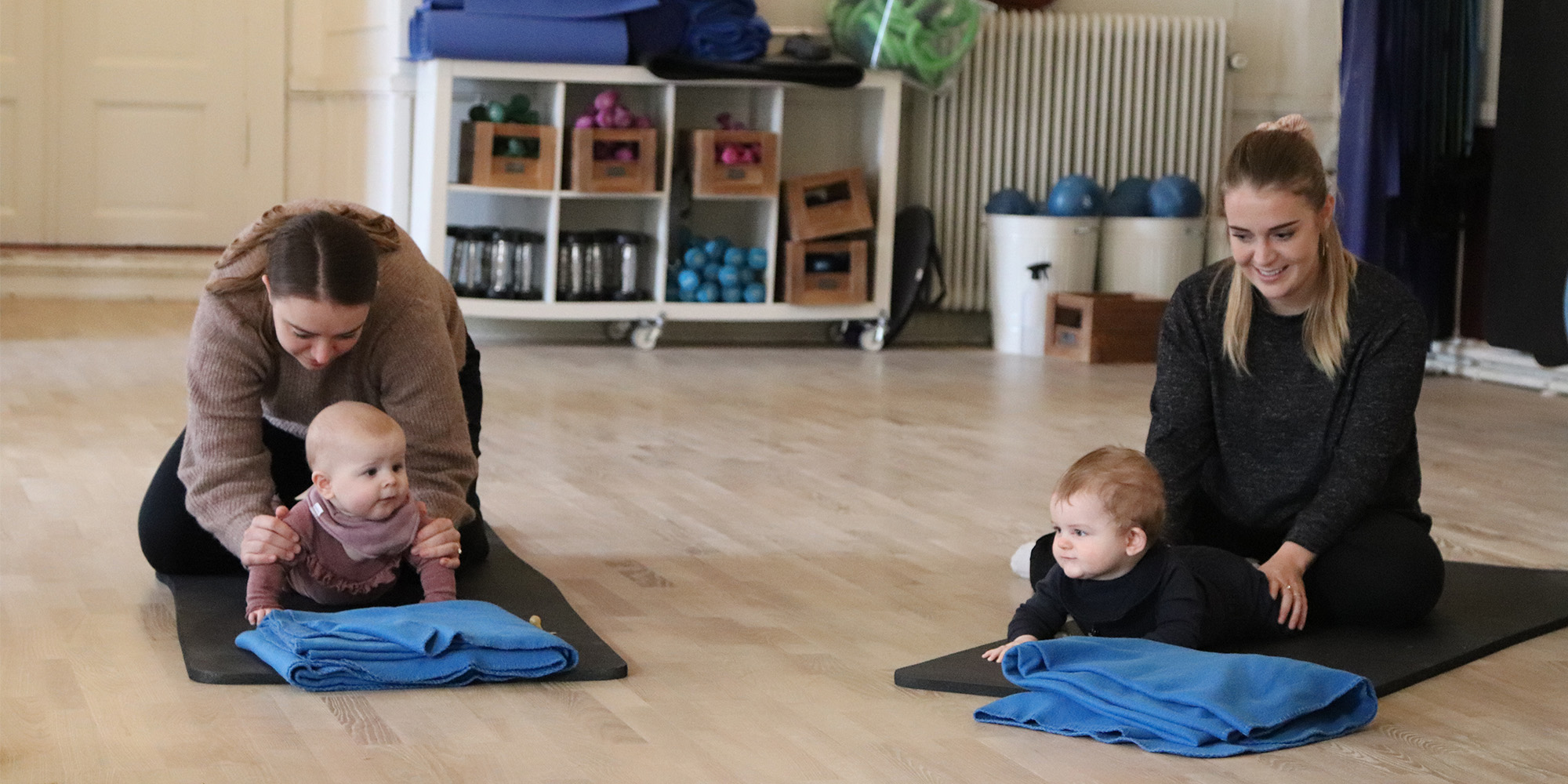 To babyer på maven laver øvelser til rytmik sammen med deres mødre - FOF i Randers - Rosenlund
