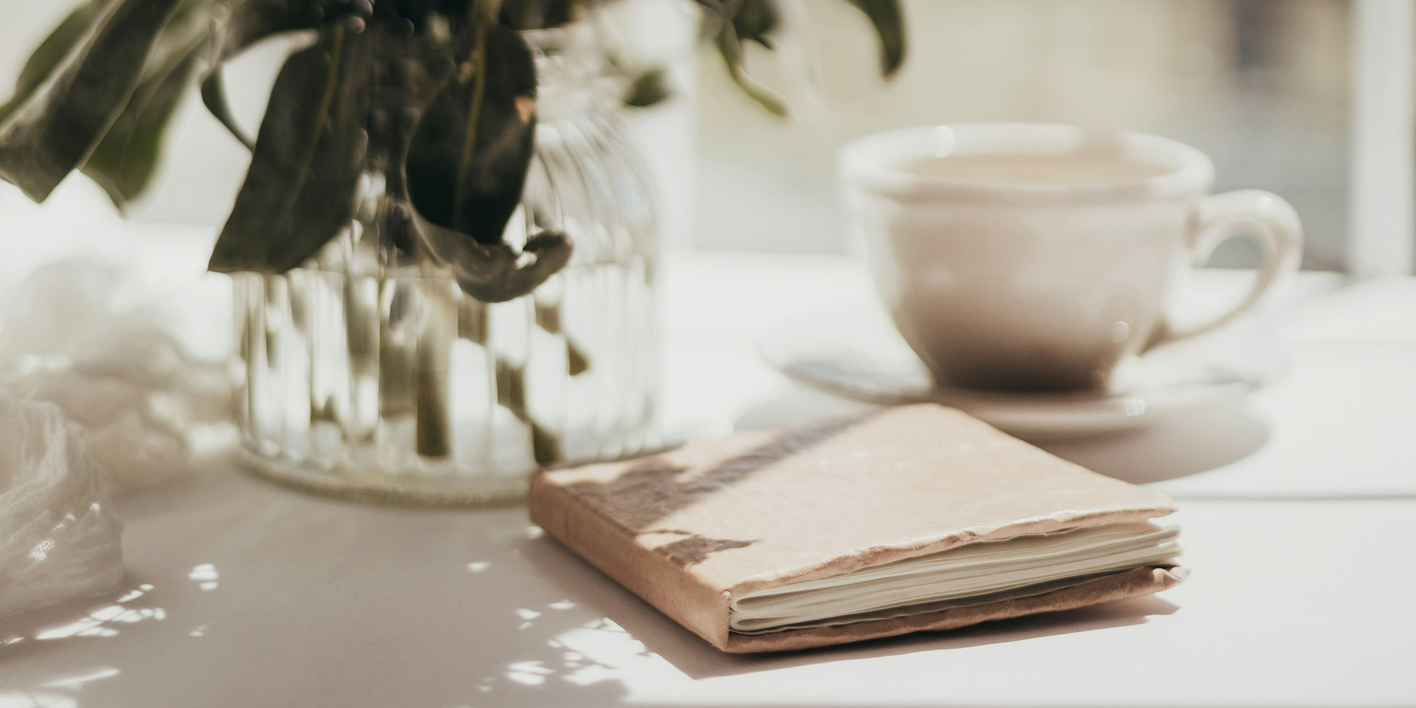 skrivning journal skrive kursus forfatter - et bord med notesbog kop og vase