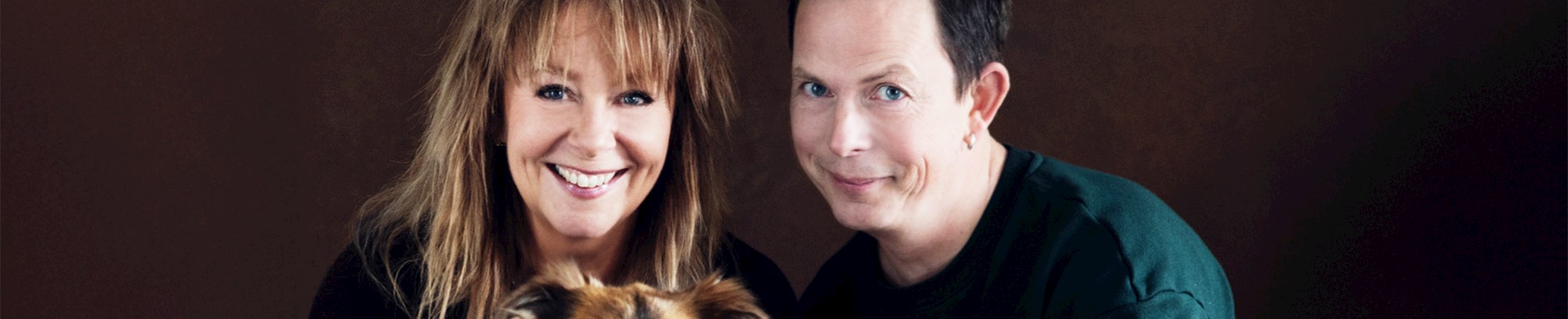 Gruppebillede af Puk Elgård og Anders Kofoed med hænderne på en hund