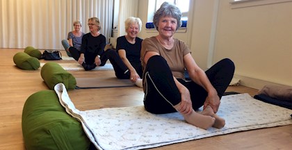 Yoga kursister, der laver stræk øvelser på yogamåtter