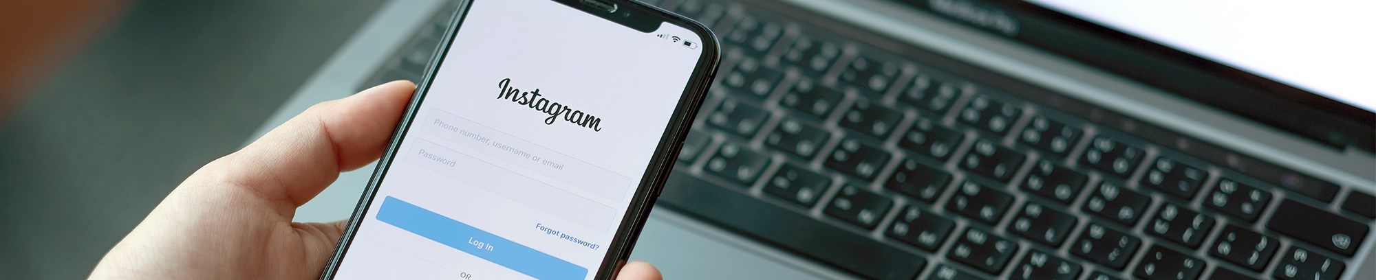 En telefon med Instagrams login side på - og en bærbar i baggrunden med Instagrams login side på