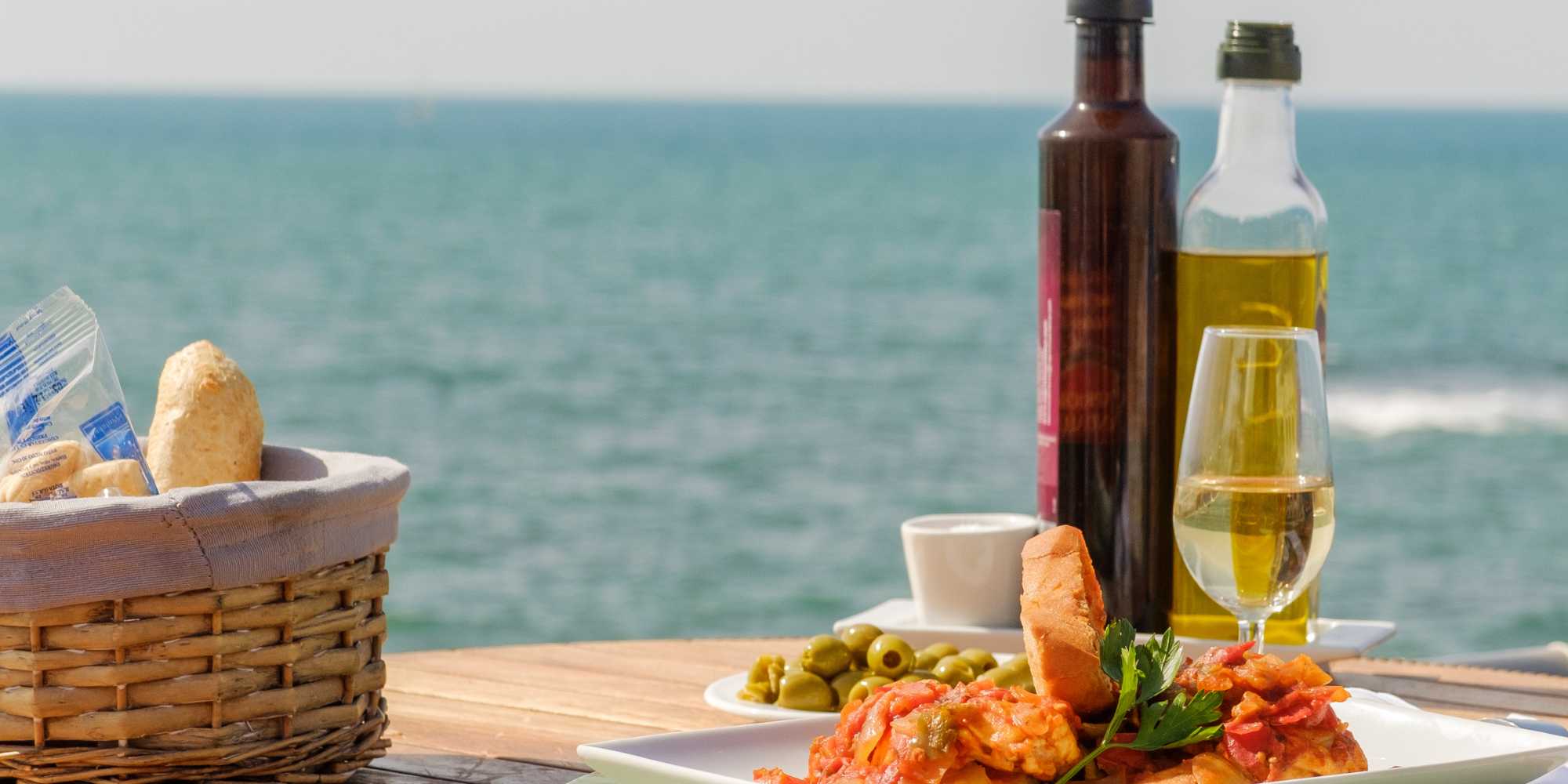 Bord med mad og drikke fra Middelhavet med udsigt til havet