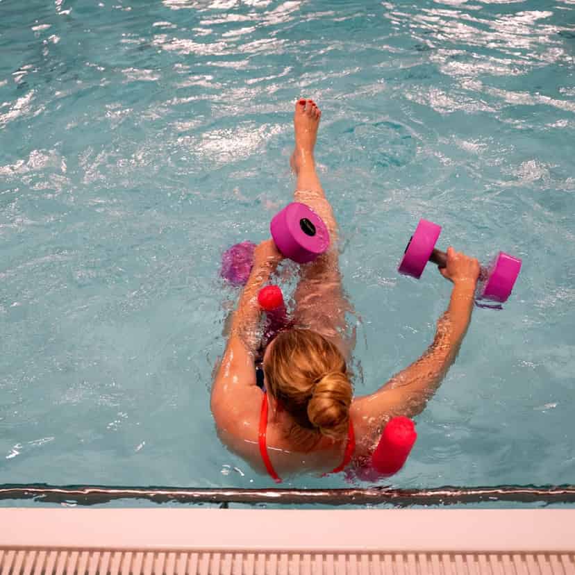 Varmtvandstræning - deltager laver øvelse i vand med håndvægte.