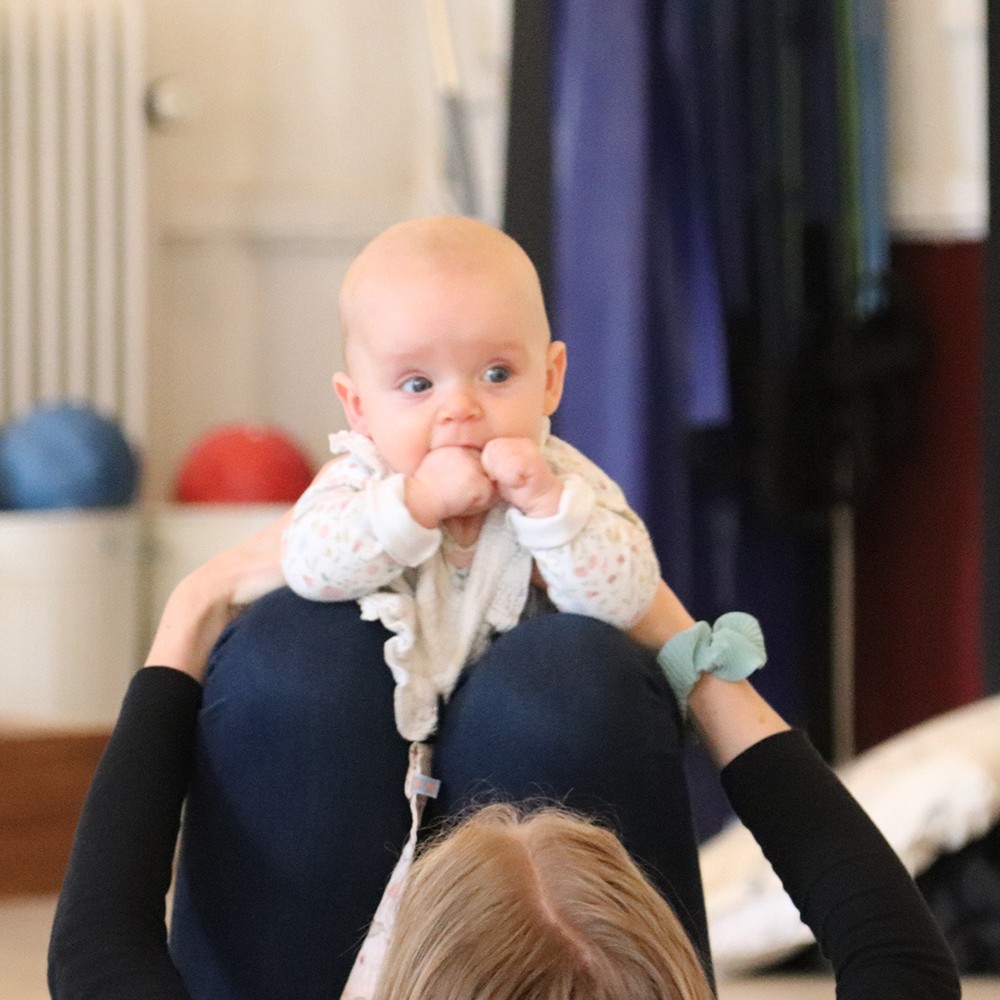 Baby kigger opmærksomt i en motorik-øvelse med forældre - Rosenlund, FOF i Randers