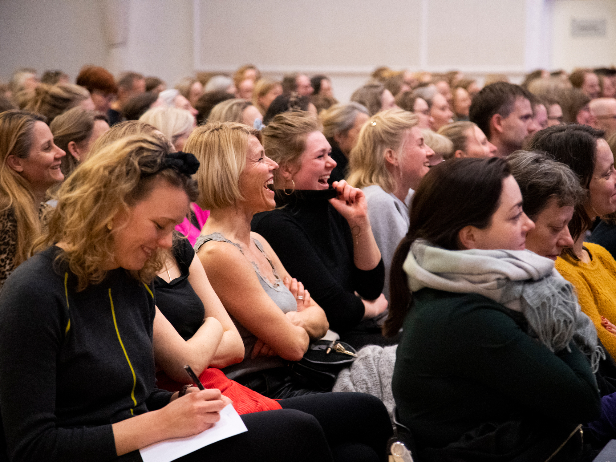 Publikum der griner til et foredrag hos FOF København og Nordsjælland