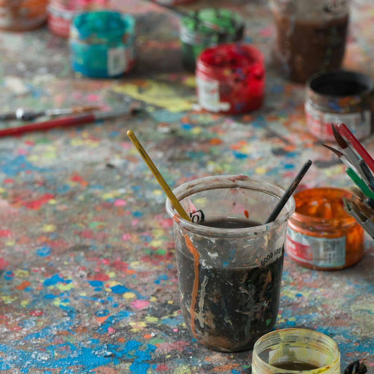 Pensler og malerpletter på et bord på kunstskolen Bifrost
