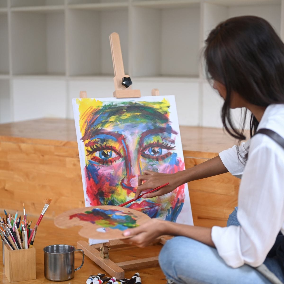 Deltager på kreativt malehold i Taastrup, der arbejder med farver og eksperimenterende teknikker