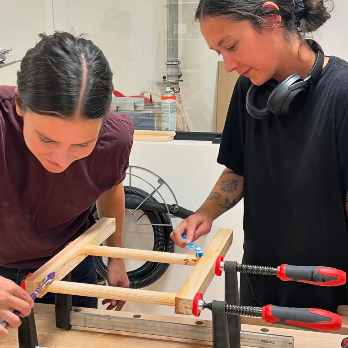 Deltagere bygger en skammel af træ med flettet sæde