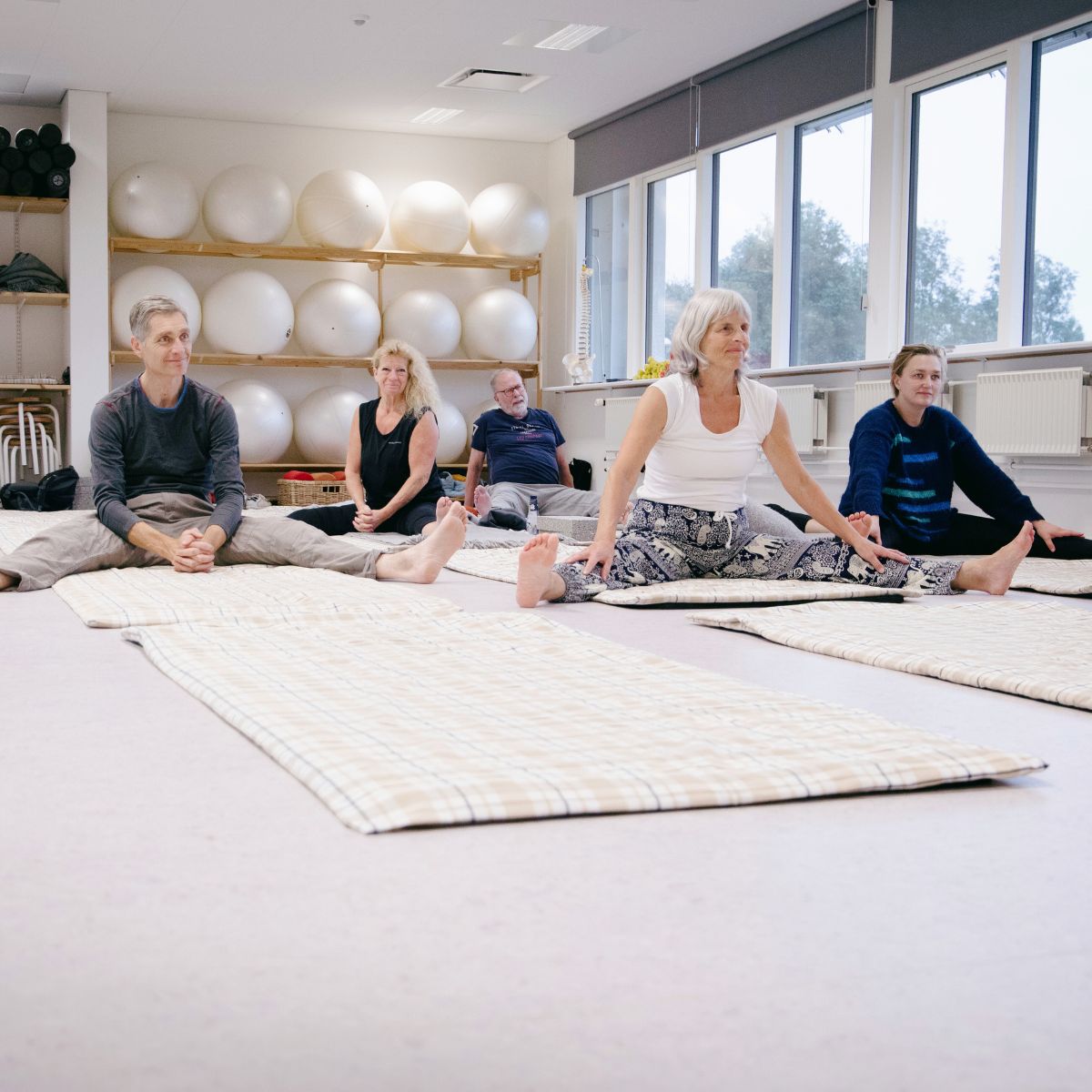 Kursister på tæpper i bevægelseslokale