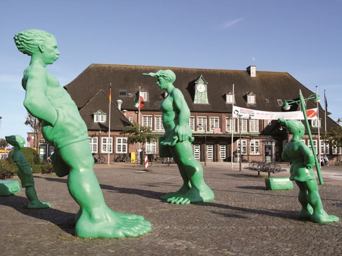 "Sylt giganter" (Sild-kæmperne) de lysegrønne skulpturer af en familie "Rejsende kæmper i vinden" af Martin Wolke