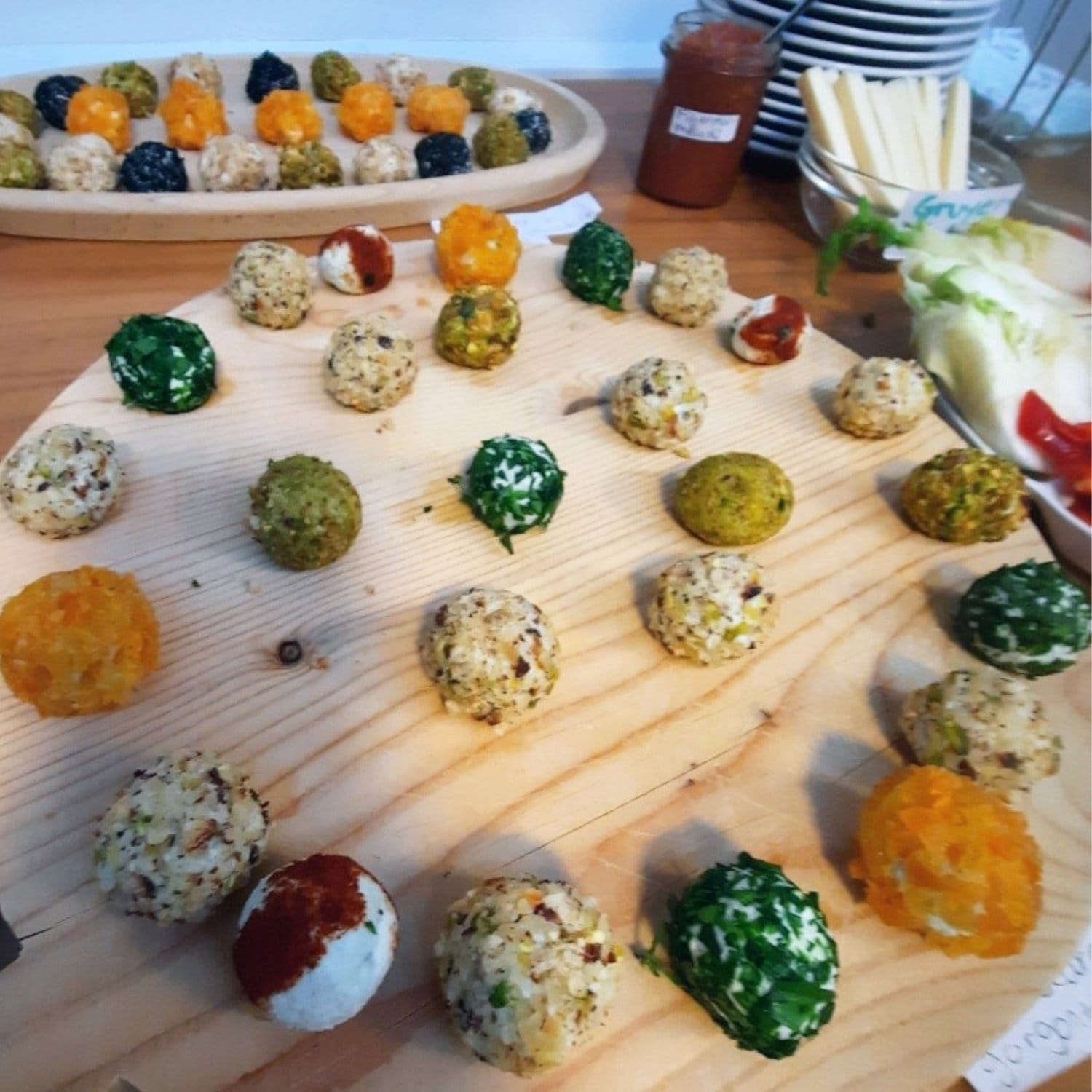 Farverige ostekugler på et træfad