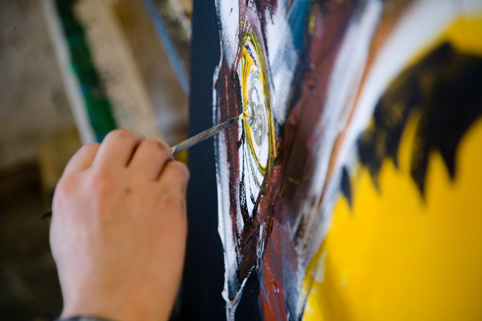 Deltager arbejder på abstrakt akrylmaleri i atelier