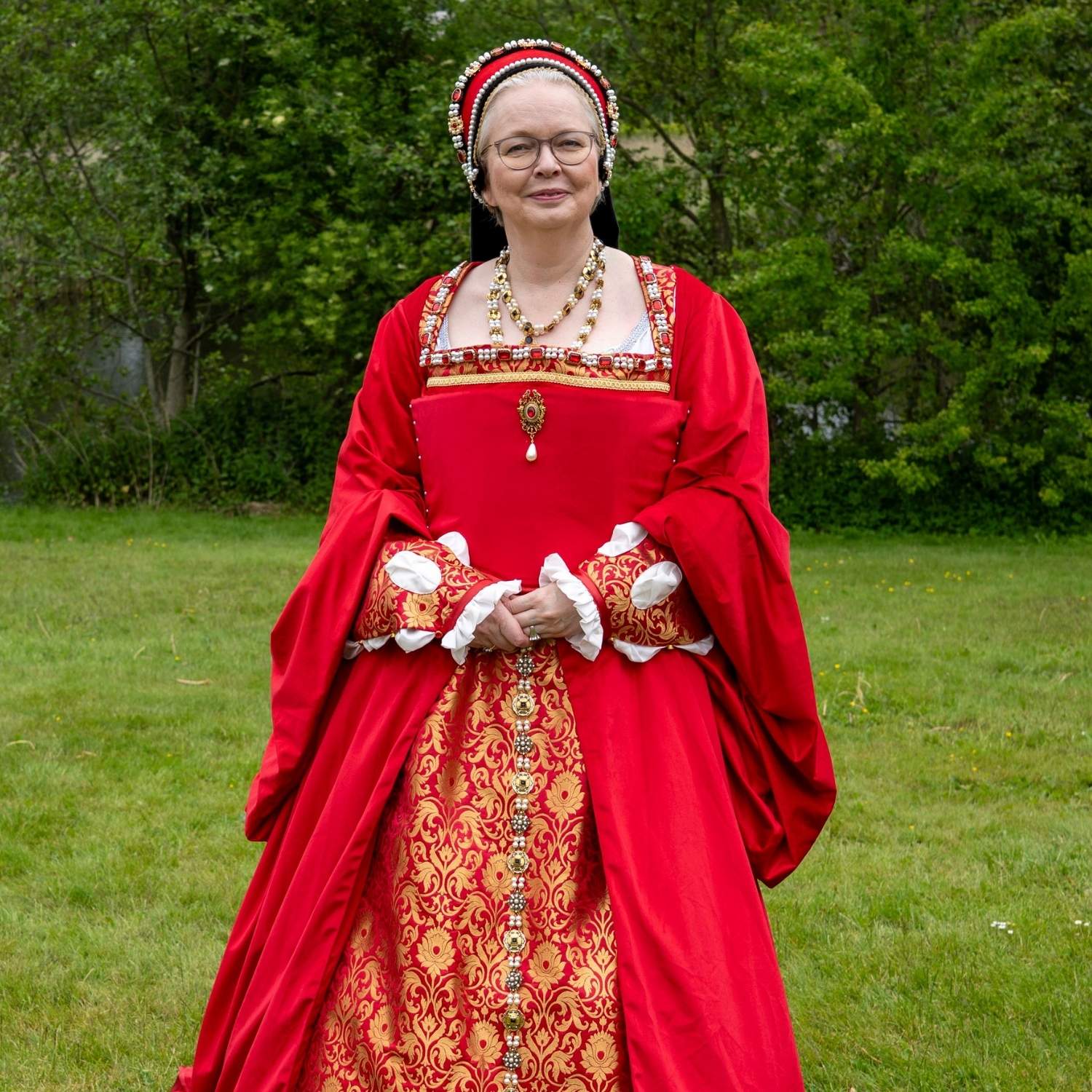 Theresia Treschow-Kühl klædt ud som Anne af Kleves i en historisk smuk rød kjole med udsmykning, osv.