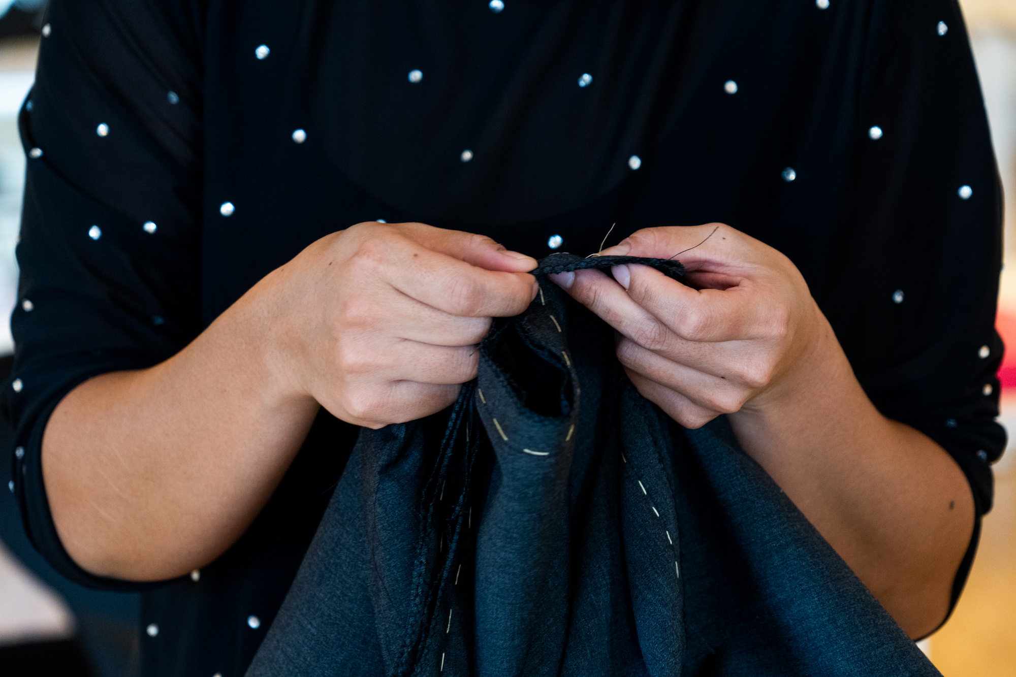 Kursist syr en klassisk jakke under kursus i jakkesyning.