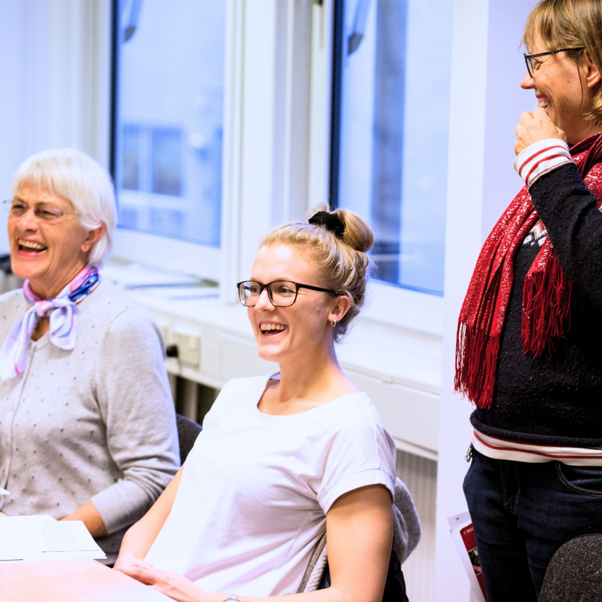 Underviser og kursister griner sammen til franskundervisning