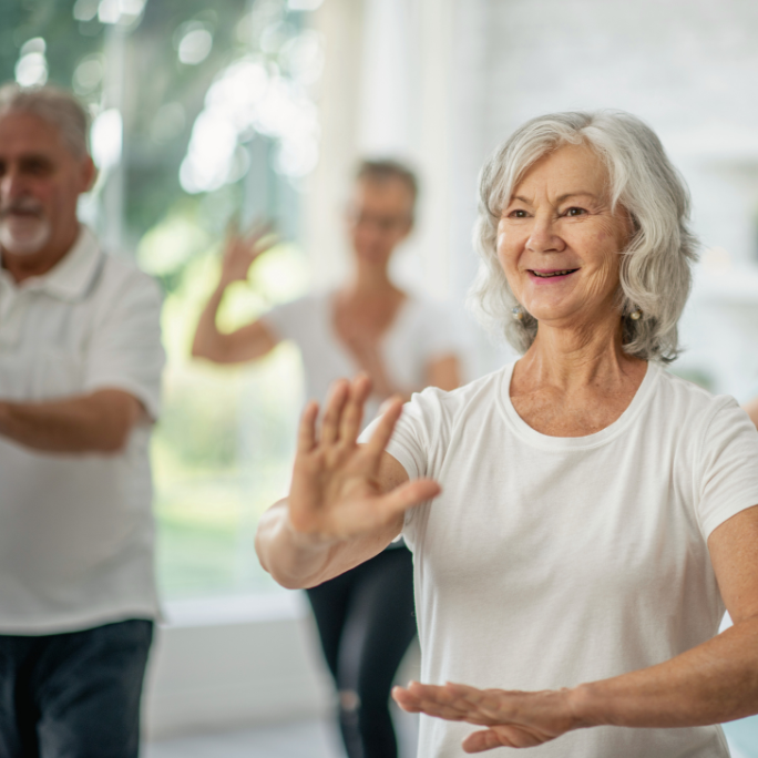 smilende kvinde i hvid tshirt på hold med tai chi / Qigong