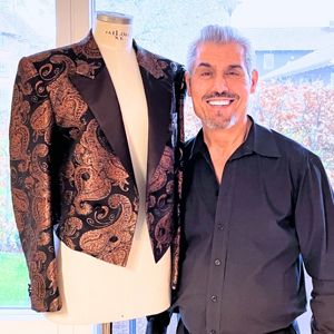 FOF underviser Ali der står ved siden af en af hans syet jakker