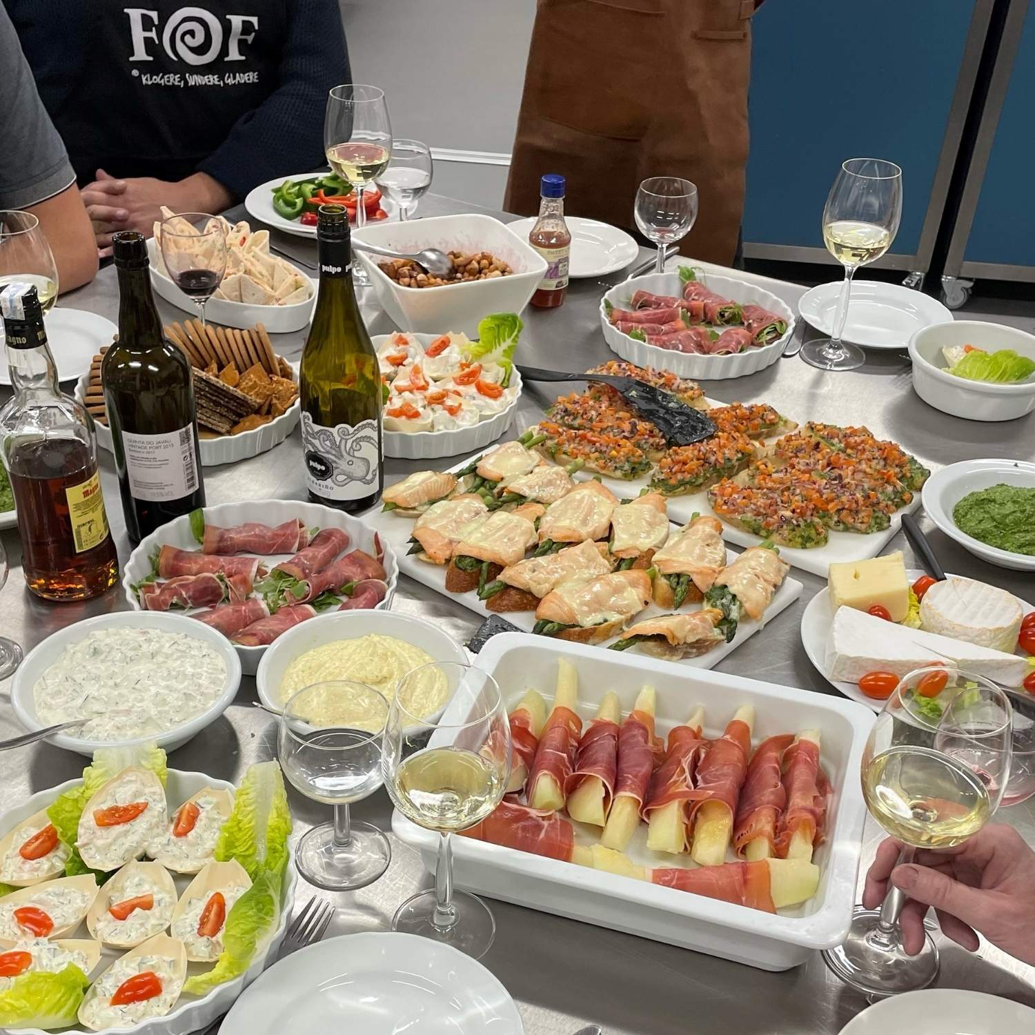 Madretter anrettet på et bord ved fællesspisningen for "Finere madlavning for mænd" i 2021