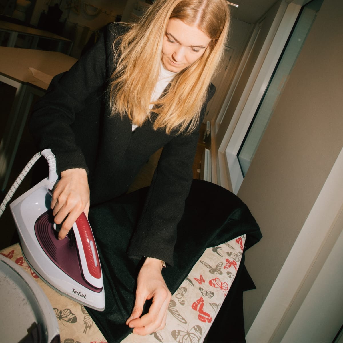 Kvinde stryger en hjemmesyet jakke på et sykursus