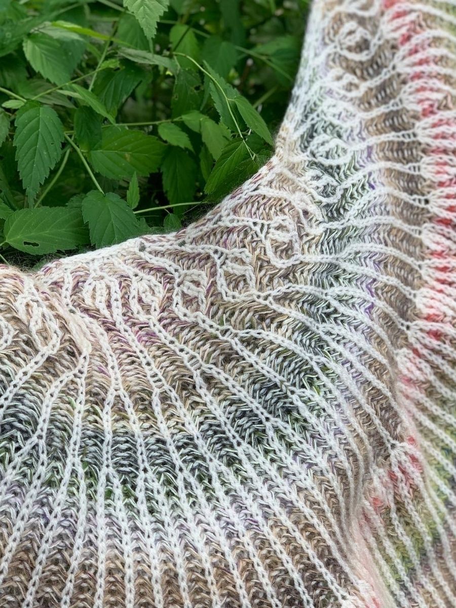 Patentstrikket sjal i multifarvet patent med markant struktur og farveskift.