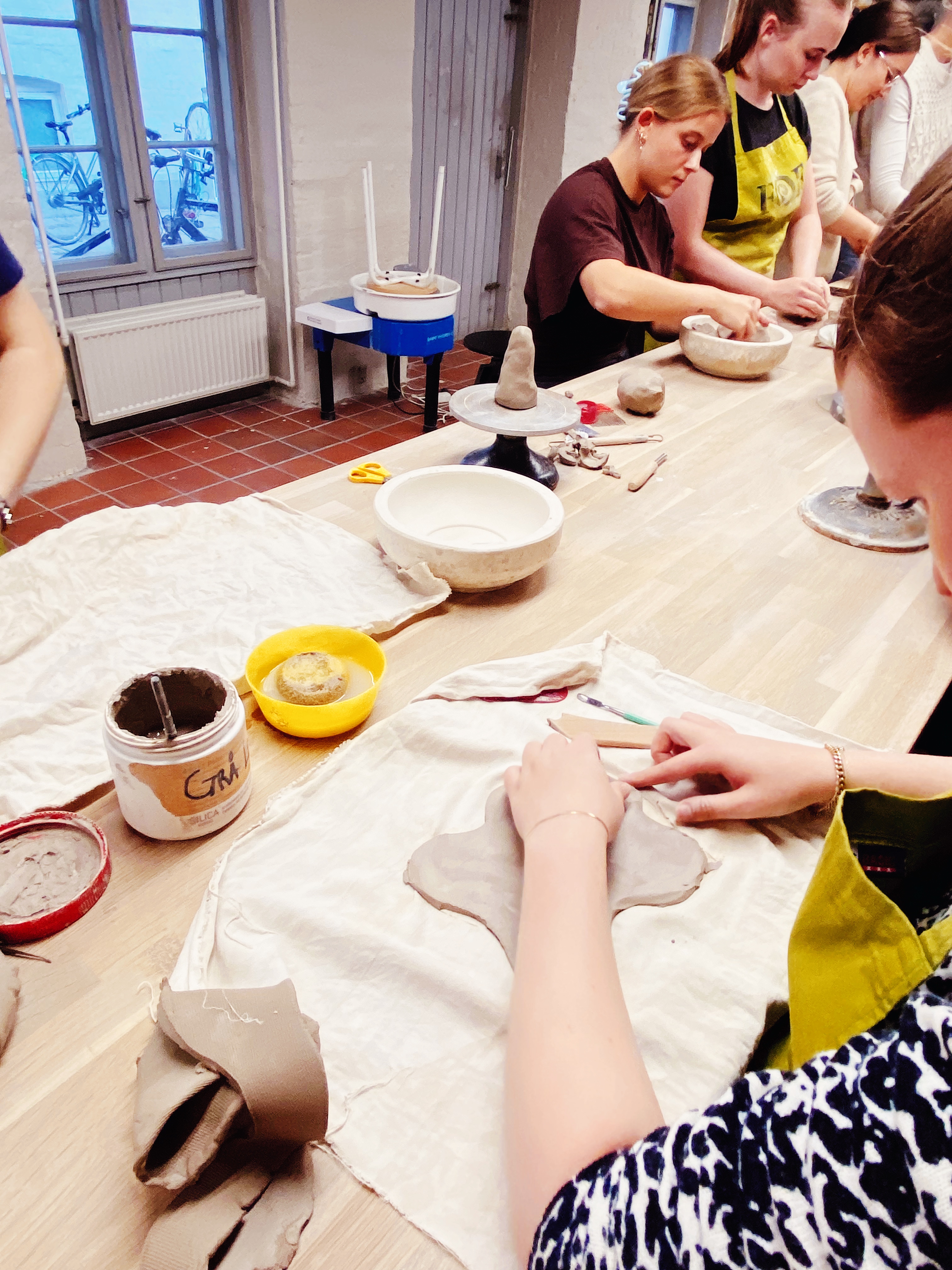 Kursist arbejder med pladeteknik i stentøjsler på FOF’s keramikworkshop.