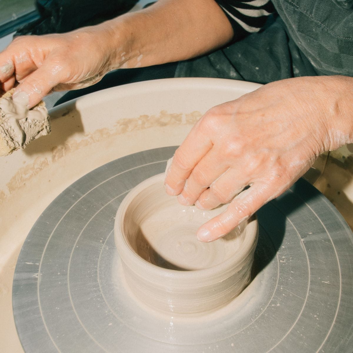 Kursist arbejder med ler på en drejeskive på et keramikkursus hos FOF København og Nordsjælland