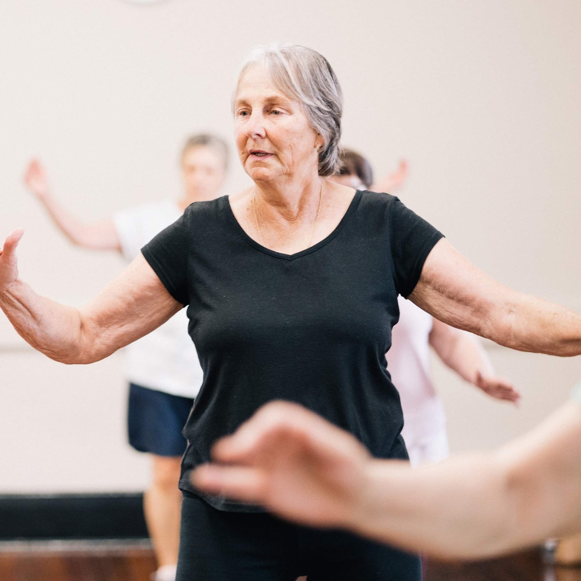 Deltager udfører præcise callanetics-øvelser med fokus på vejrtrækning og holdning