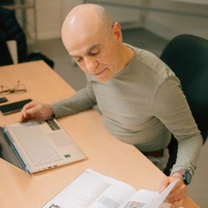 Mand der sidder og kigger på sine papir i sprogundervisning hos fof aftenskolen