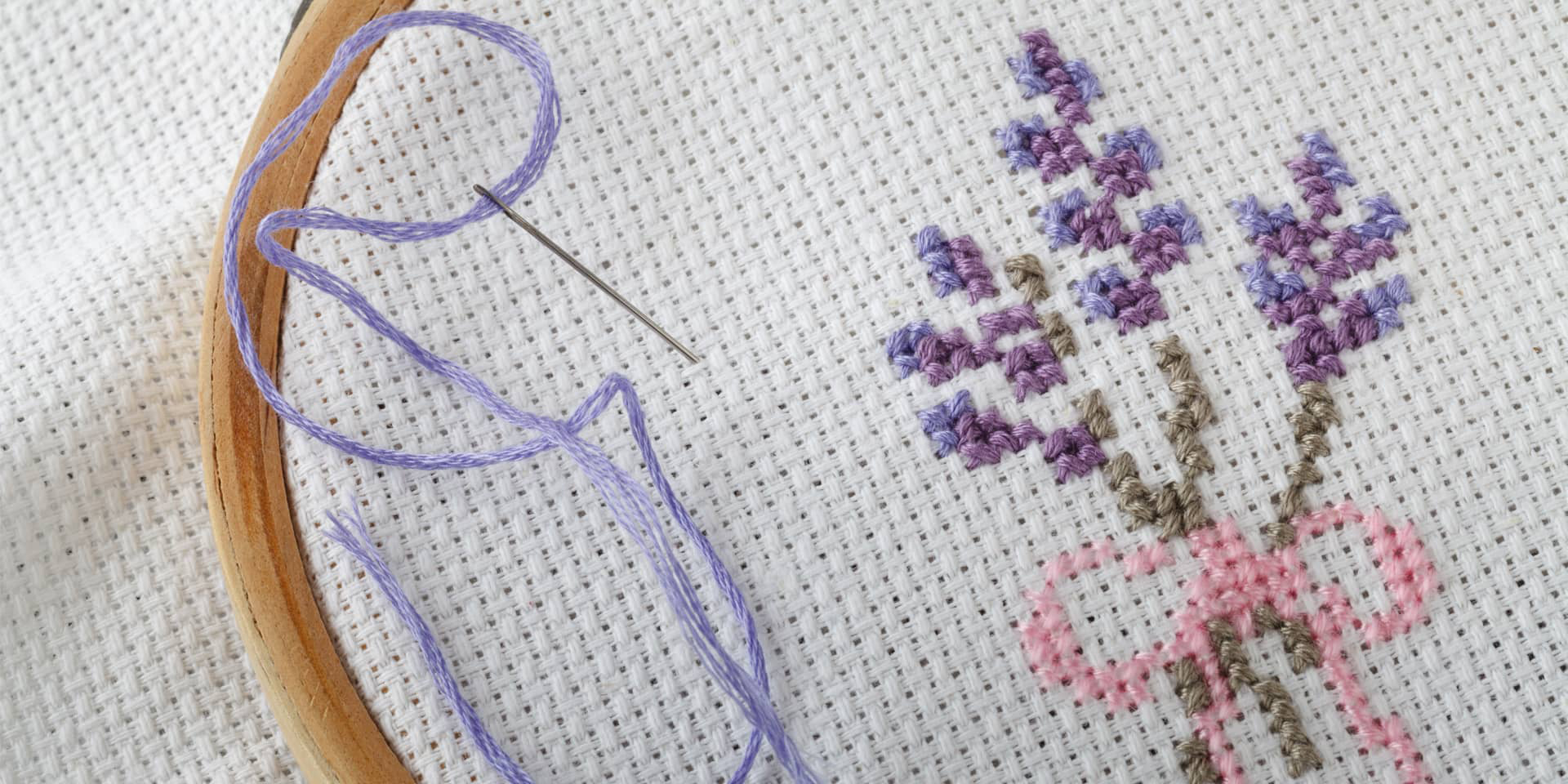 Broderi. Nål, tråd og en broderet blomst. Til broderikursus i FOF Aarhus