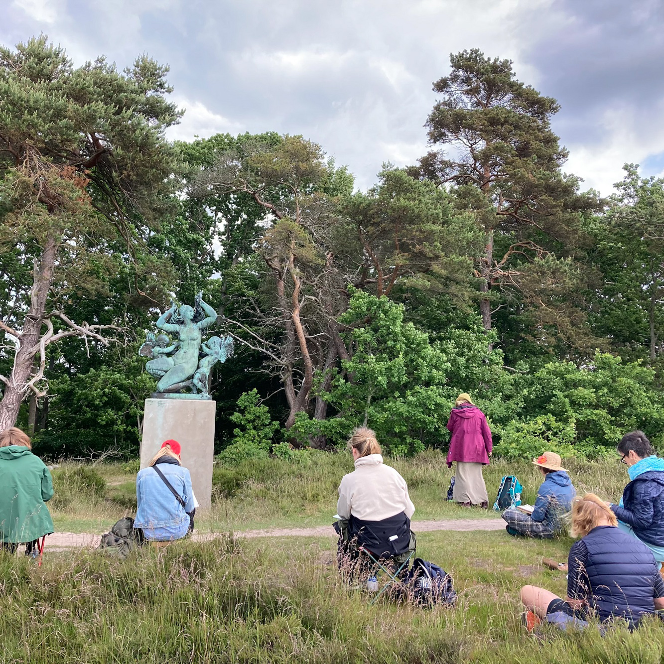 Kursister på tegnekursus tegner skulptur i park