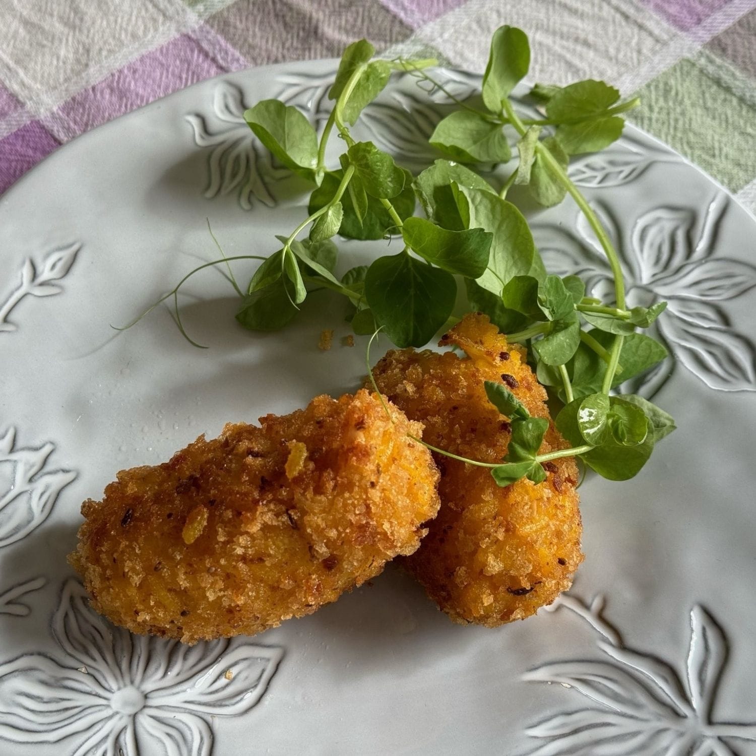 Romerske ris kroketter med garniture på en tallerken med blomster på
